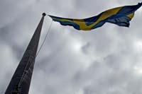 [#1525s] Svenska flaggan, svensk flagga, gul och blå, blåst, flaggstång, grå himmel, idébild
