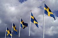 [#2195m] Svenska flaggan, svensk flagga, svenska flaggor, fyra, gul och blå, blå himmel, vita moln, flaggstänger, idébild
